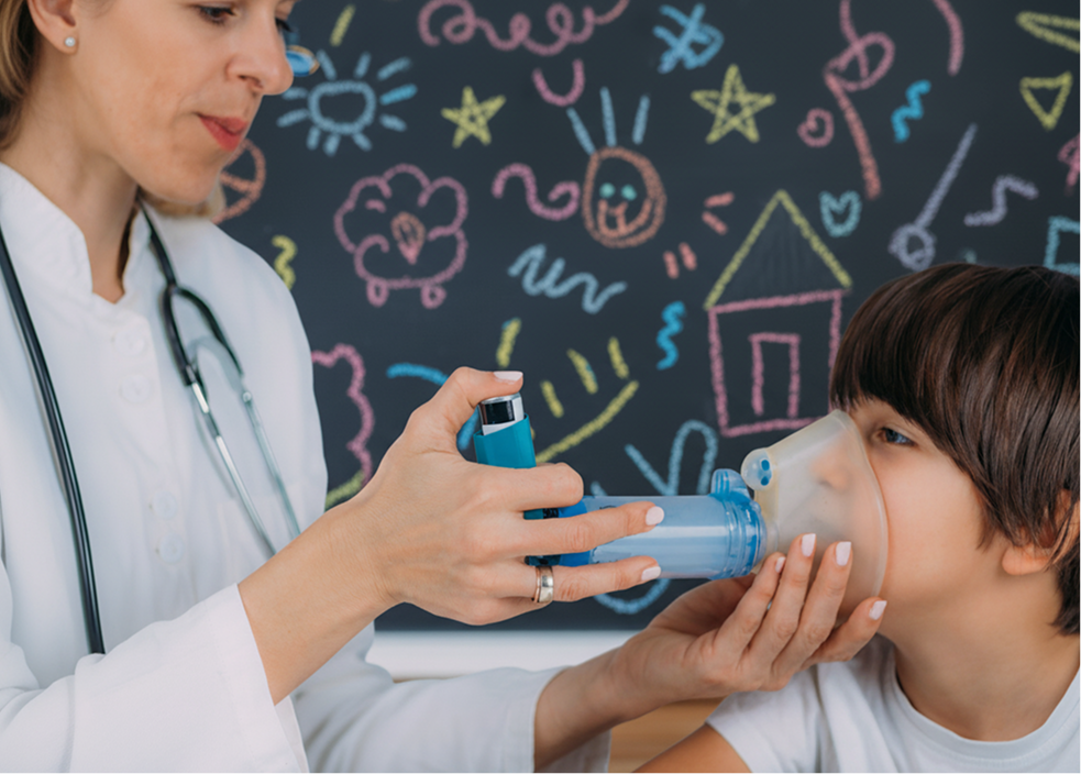 Niño utilizando un inhalador con ayuda de profesional médico